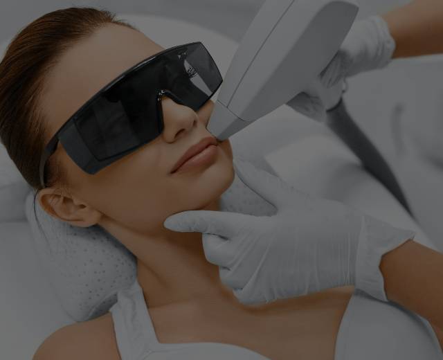 A beautiful woman wearing dark laser glasses undergoing a Laser Hair Removal treatment at Mark Medical Care.